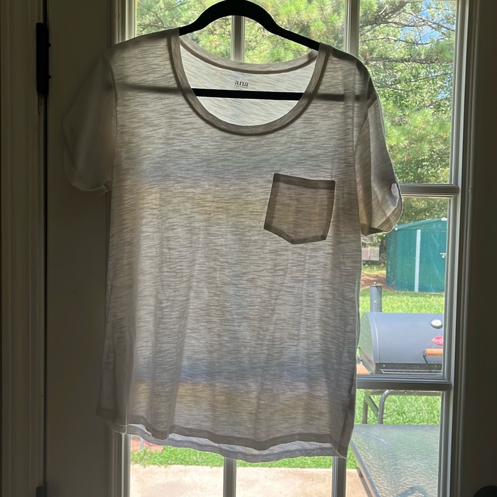 White Ana shirt with a little pocket in the front. kind of sheer fabric